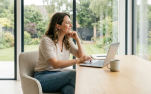 Modern entrepreneur sitting confidently at a clean workspace with a laptop, representing winning on your own terms and sustainable business success